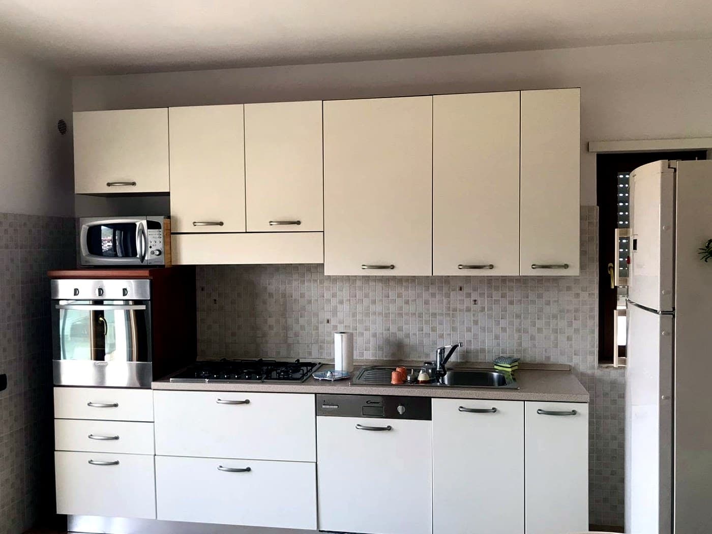 Cucina attrezzata con forno, microonde e lavastoviglie